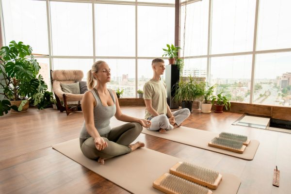 young-serene-couple-in-sportswear-sitting-in-pose-of-lotus-and-meditating.jpg